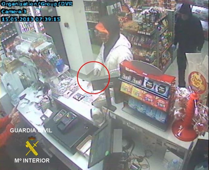 Los detenidos, en el momento del robo portando un cuchillo.