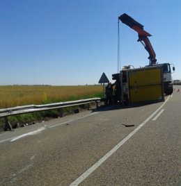 Una grúa en las labores de limpieza de la calzada con el camión siniestrado.