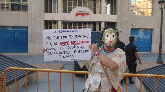 Una manifestante frente a la sede del PP valenciano 