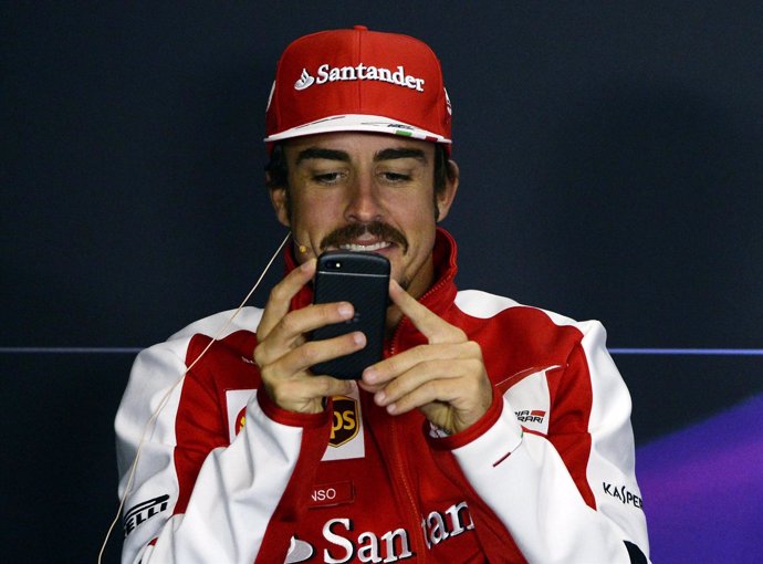 Fernando Alonso juega con su teléfono móvil en Silverstone
