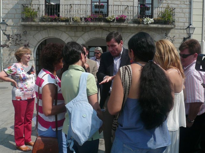 El secretario general del PSM, Tomás Gómez, hablando con padres de un instituto