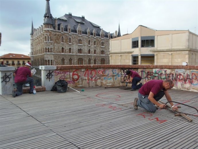 Operarios reparando la tarima de la muralla romana de León.