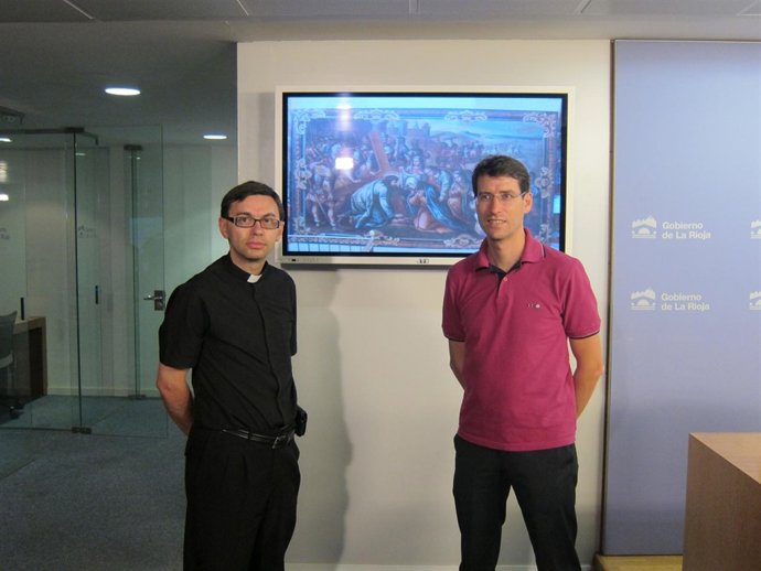 El consejero y el parroco posan antes una imágen del lienzo