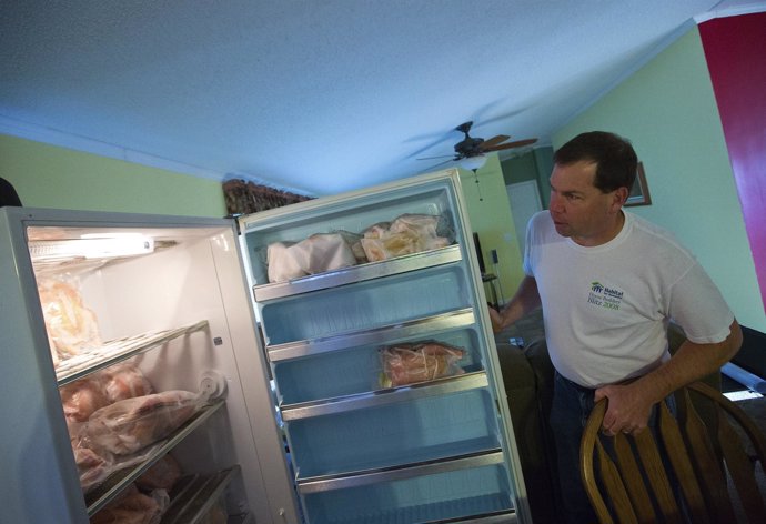 Jeff Nice looks into one of his two freezers where he keeps frozen chickens at h