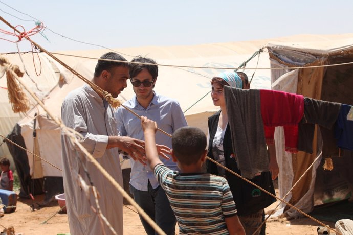 Gael Garcia Bernal talking with Hussein al-Muhammad, a resident of the tented se