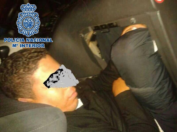 Inmigrante oculto bajo la guantera de un vehículo