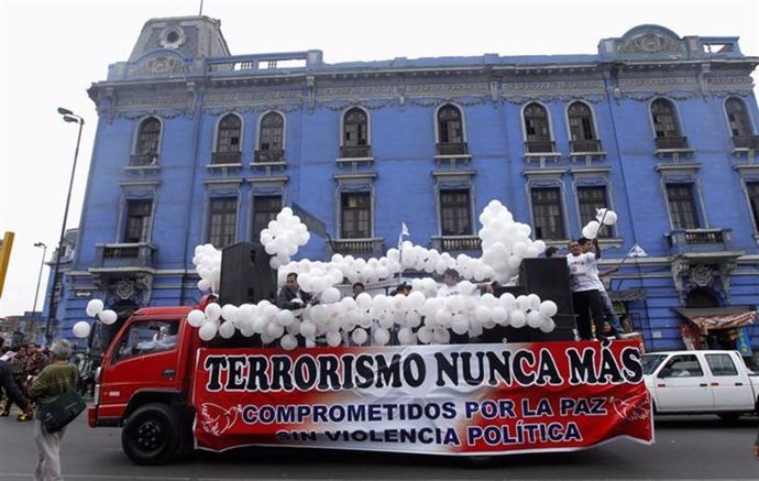 Un vehículo con un cartel contra la violencia del terrorismo en Perú participa d