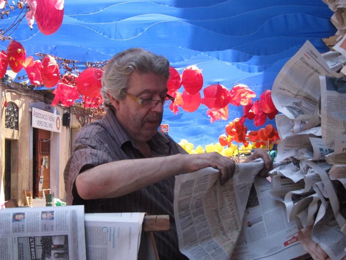 Un voluntario decorando la calle Verdi para la Fiesta Mayor de Gràcia