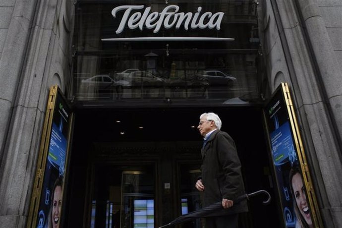 Un hombre camina frente a un edificio de Telefónica en el centro de Madrid. Foto