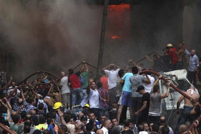 Partidarios del movimiento Hezbollah intentan apagar un incendio después de una 