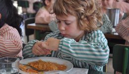 Niño comiendo en una escuela catalana, beca comedor