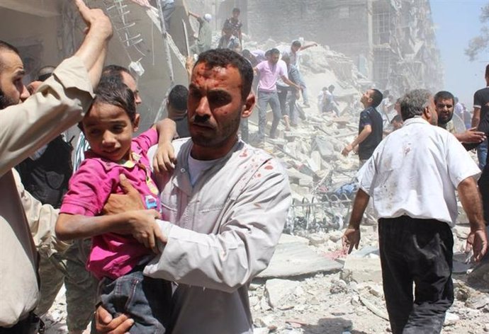 Un hombre intenta evacuar a un niño después de un bombardeo que según activistas