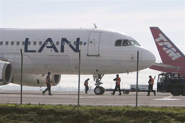 Un avión de LAN y otro de TAM estacionados en el aeropuerto internacional de San