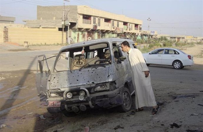 Un residente inspeciona un vehículo dañado por un ataque con coche bomba al nort