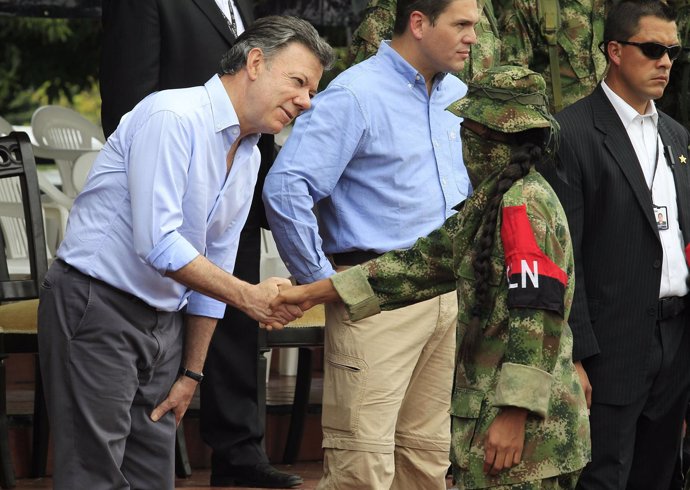 Juan Manuel Santos saluda a un miembro del grupo guerrillero ELN
