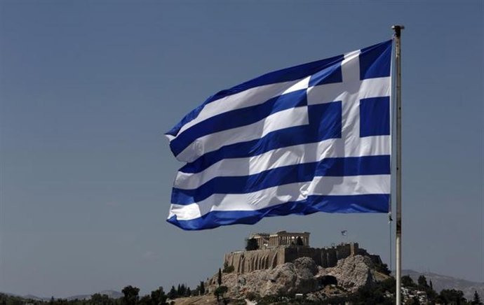 Una bandera de Grecia ondea frente a la Acrópolis en Atenas. Agosto 21, 2013. RE