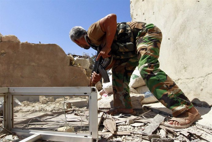 Un soldado del Ejército de Siria Libre se refugia en un enfrentamiento con fuerz