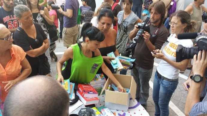 Miembros del SAT reparten material escolar en la Corrala Utopía