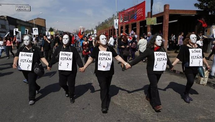 Manifestantes marchan por Santiago portando carteles que preguntan "¿Dónde están