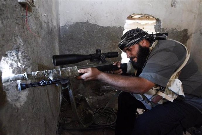 Un combatiente del rebelde Ejército de Siria Libre apunta su arma sobre un aguje