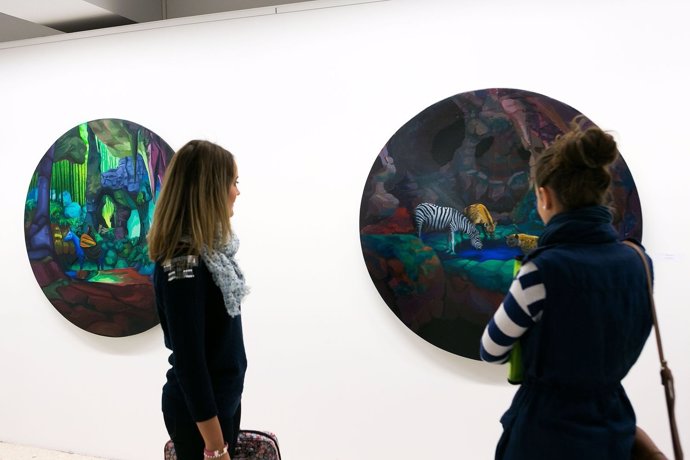 Dos estudiantes observan uno de los cuadros