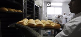 Un trabajador retira pan recién horneado en la panadería Ceci de Sao Paulo