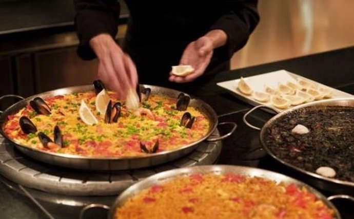 Cocinero cocinando una paella. Comida/Cena 