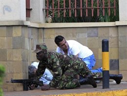 Un soldado keniano se resguarda tras una pared junto a sobreviviente del ataque 