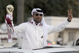Imagen de archivo de un qatarí celebrando con una réplica de la Copa Mundial de 