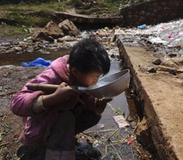 Niño pobre bebiendo agua