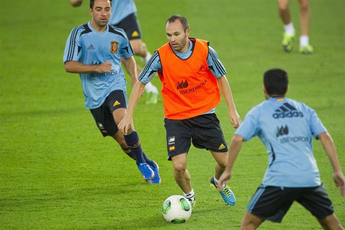 Iniesta conduce el balón ante Xavi