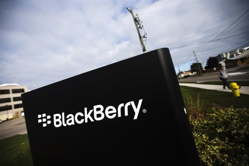 Un hombre camina cerca de un anuncio de BlackBerry en su campus de Waterloo, Can