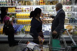 Personas observando productos de un supermercado de Caracas, Venezuela (2013).