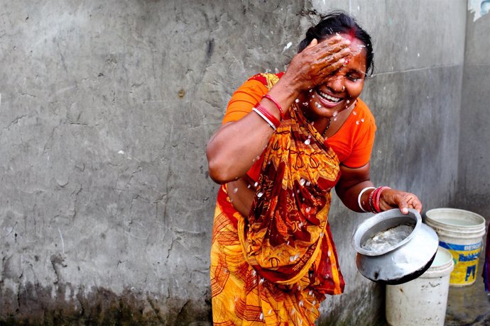 A woman is washing face early in the morning in TT Para Slum, Komlapur.