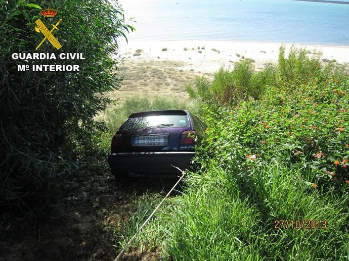 Coche rescastado a punto de caer por un barranco en Mazagón (Huelva).