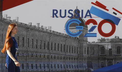 Una empleada pasa junto a un símbolo de la cumbre G-20 en Strelna cerca St. Pete