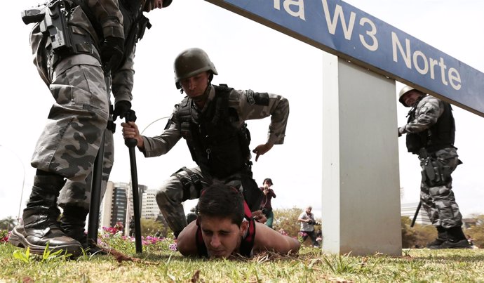 Miembros de la Policía Militar deteniendo a un ciudadano brasileño.