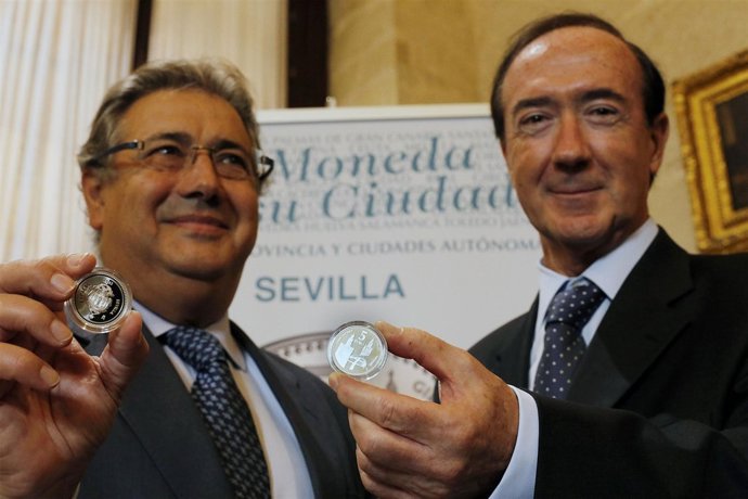 Zoido y Sánchez Revenga con la moneda de Sevilla