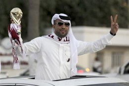 Imagen de archivo de un qatarí celebrando con una réplica de la Copa Mundial 