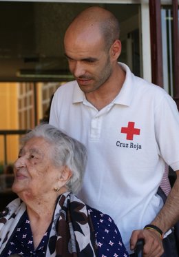 Voluntario De Cruz Roja Con Una Persona Mayor