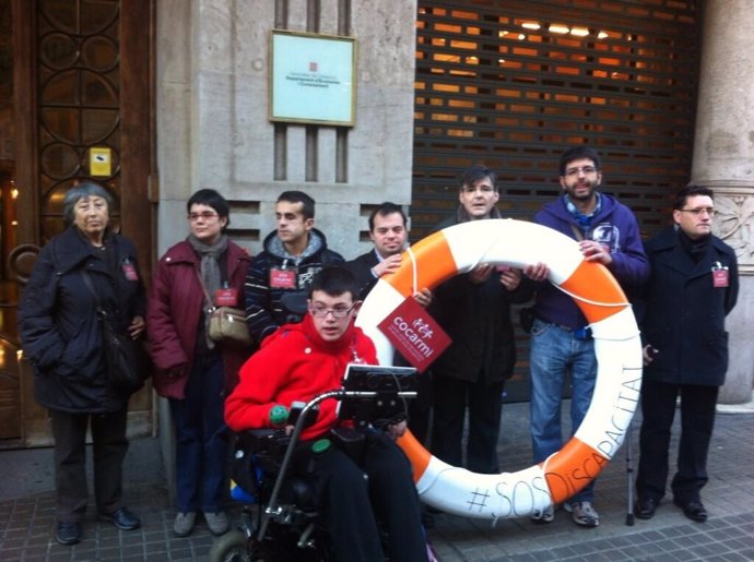 Discapacitados exhiben un flotador ante Economía contra los recortes