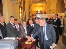 Miembros de la Mesa realizan el primer  matasellado simbólico. 