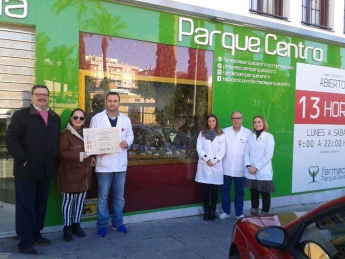 Carlos García y Pilar Benítez hacen entrega del primer premio a la  farmacia