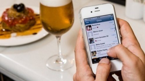 Teléfono móvil smartphone iPhone en un bar cafetería cerveza tapa