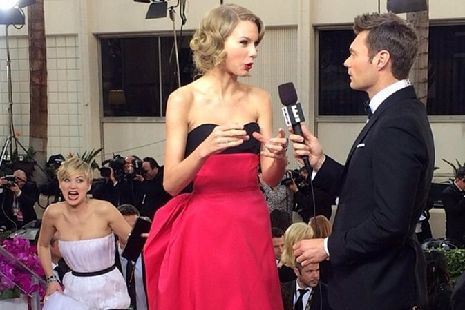 Jennifer Lawrence poniendo muecas detrás de Taylor Swift en los Globos de Oro