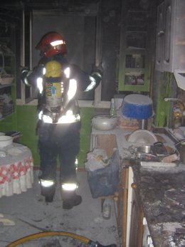 Un Bombero Del 112 En Una Cocina Calcinada Tras Un Fuego. 