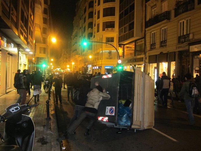 Manifestantes vuelcan un contenedor en la calle San Vicente de Valencia
