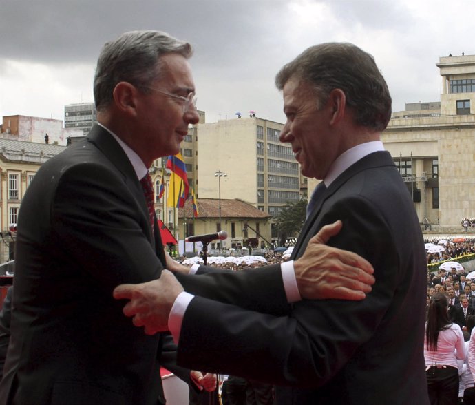 El expresidente Álvaro Uribe saluda al actual dirigente Juan Manuel Santos