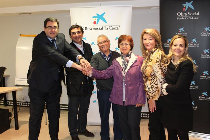 Representantes de los comerciantes y directores de sucursales de la Caixa en la 