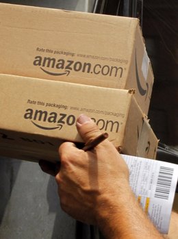 Un hombre transporta dos paquete de Amazon.com en Boston, Massachusetts